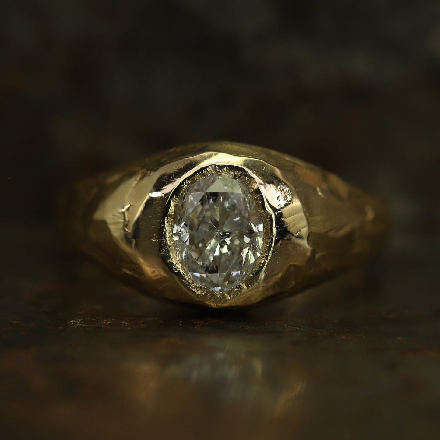 Ellis Mhairi Cameron - Gold ring with a diamond on a dark background