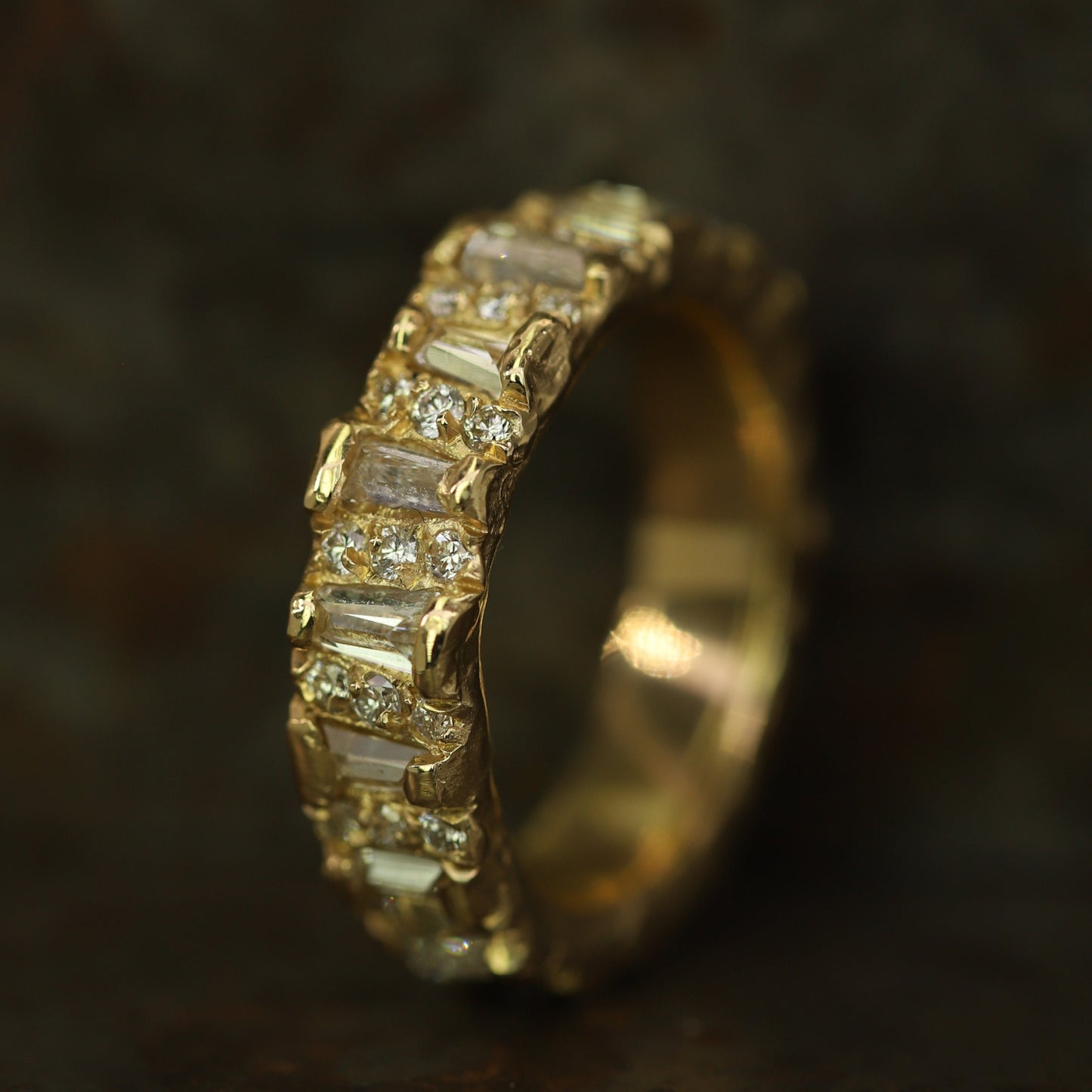 Ellis Mhairi Cameron - Gold ring with diamond accents on a dark background
