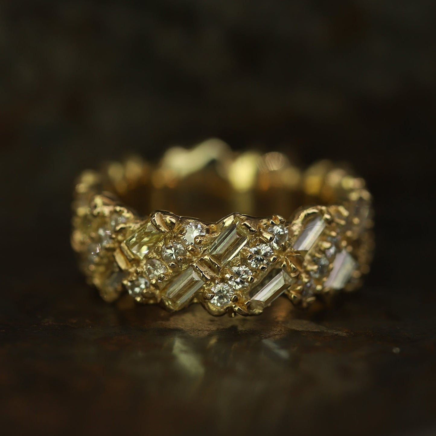 Ellis Mhairi Cameron - Gold ring with diamond accents on a dark background