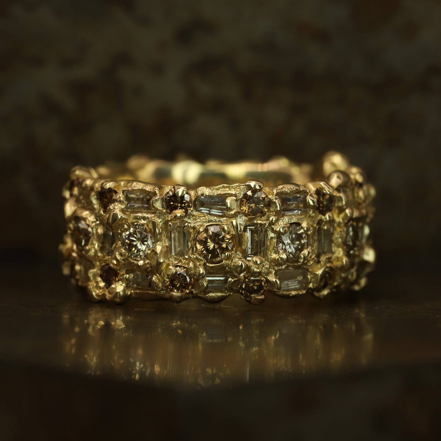 Ellis Mhairi Cameron - Gold ring with diamond accents on a dark background
