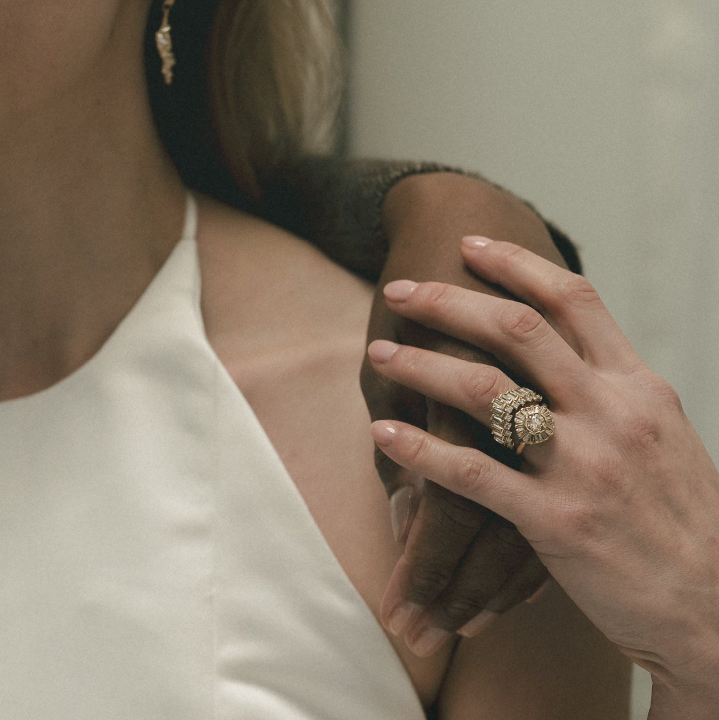 Ellis Mhairi Cameron - Close-up of a woman's hand wearing a ring with a blurred background
