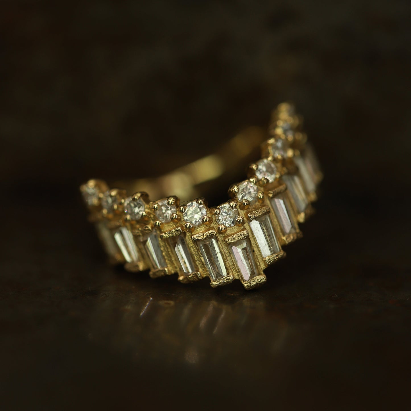 Ellis Mhairi Cameron - Gold ring with diamond accents on a dark background