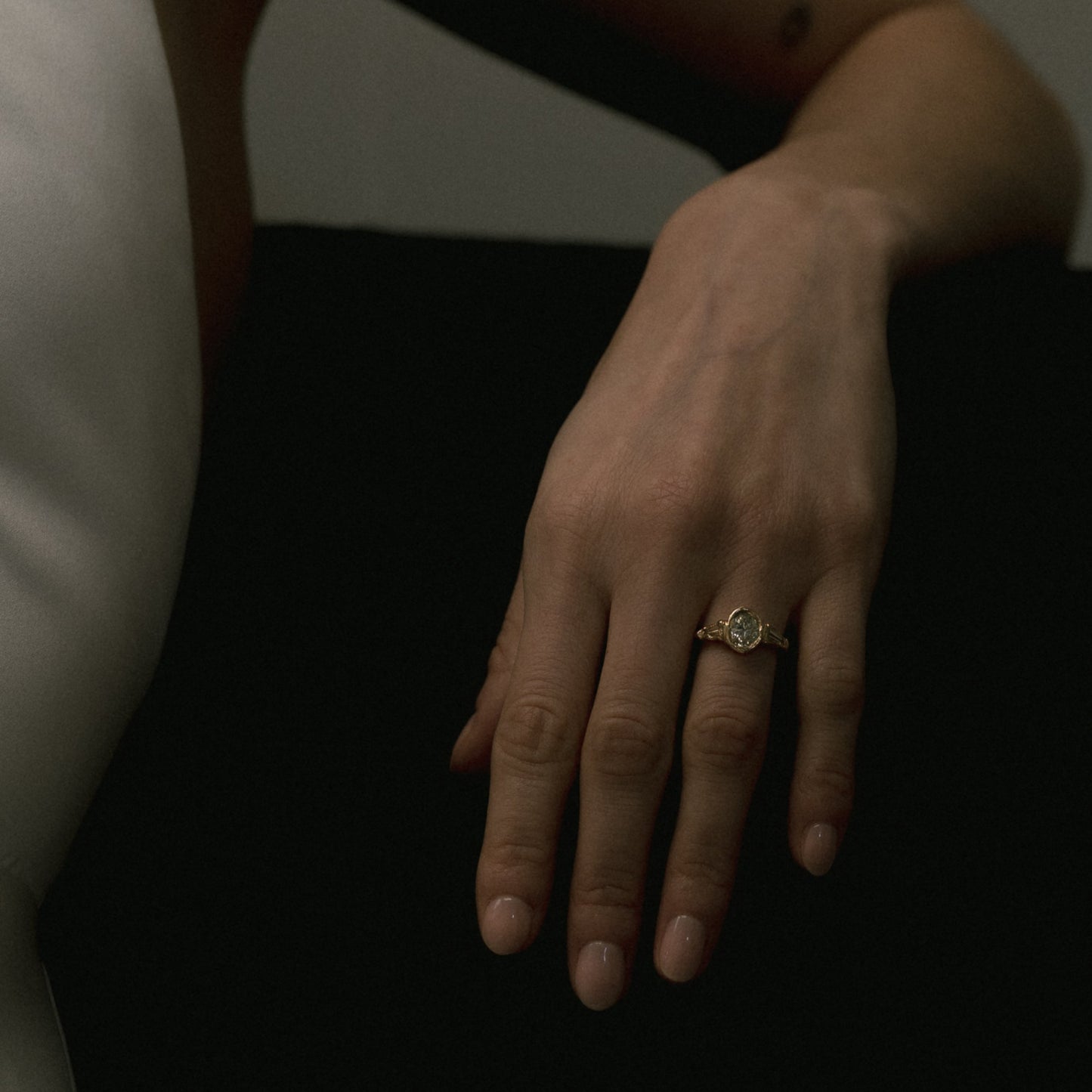 Ellis Mhairi Cameron - Hand with a ring on a dark surface