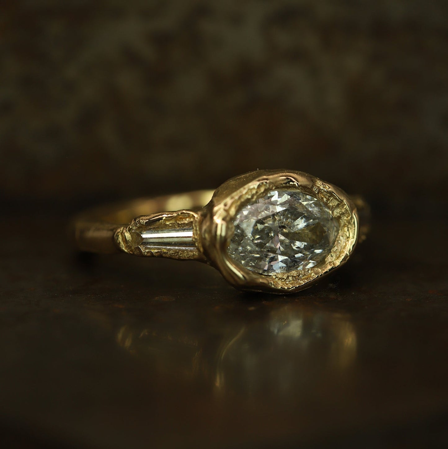 Ellis Mhairi Cameron - Gold ring with a diamond on a dark background