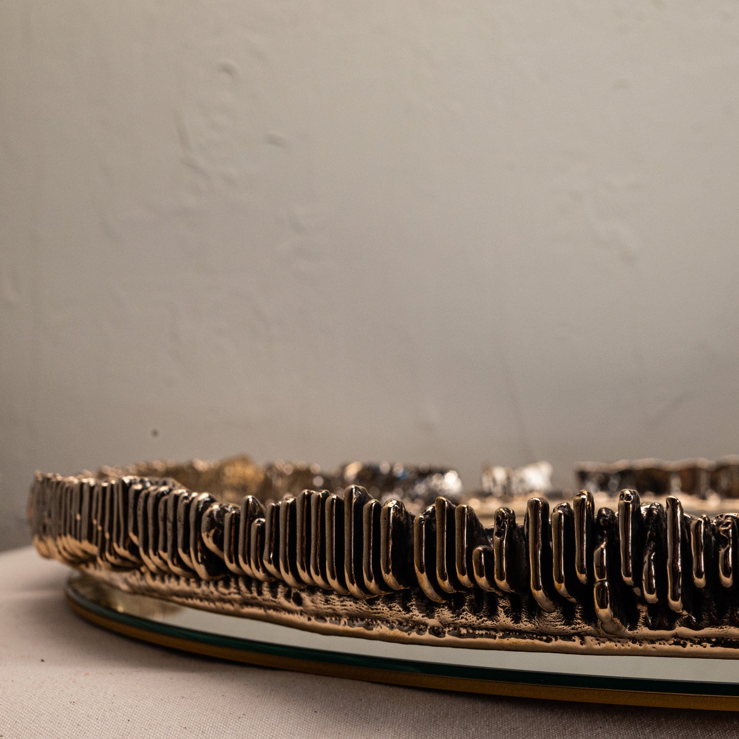 Decorative mirror detailed view of metal textured edge on a neutral background
