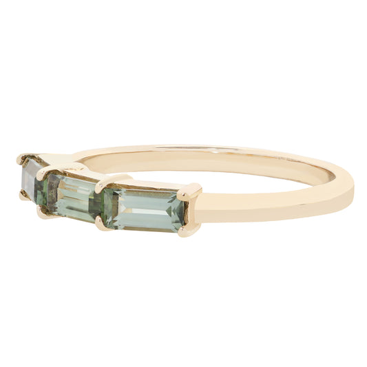 A yellow gold ring featuring three rectangular baguette-cut light green gemstones in a prong setting, shown against a plain white background.