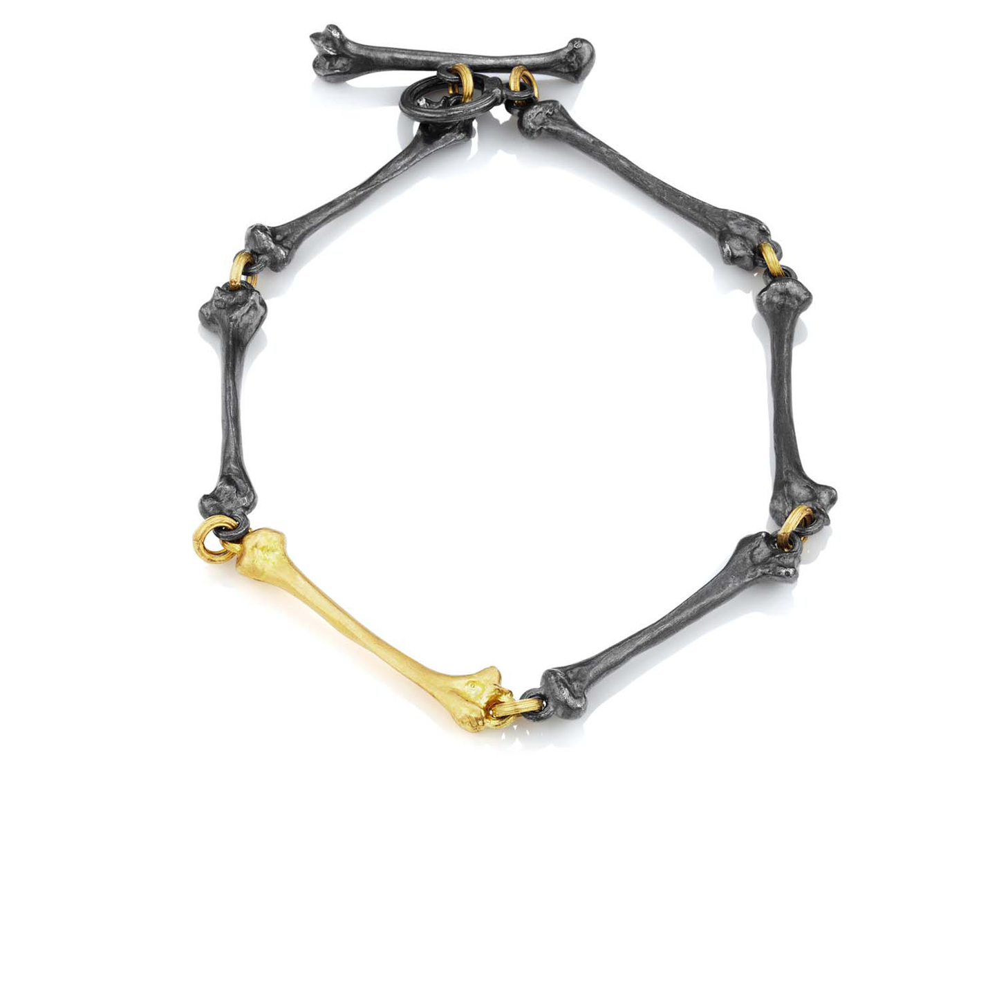 Bracelet with black and gold bone-like design on a white background