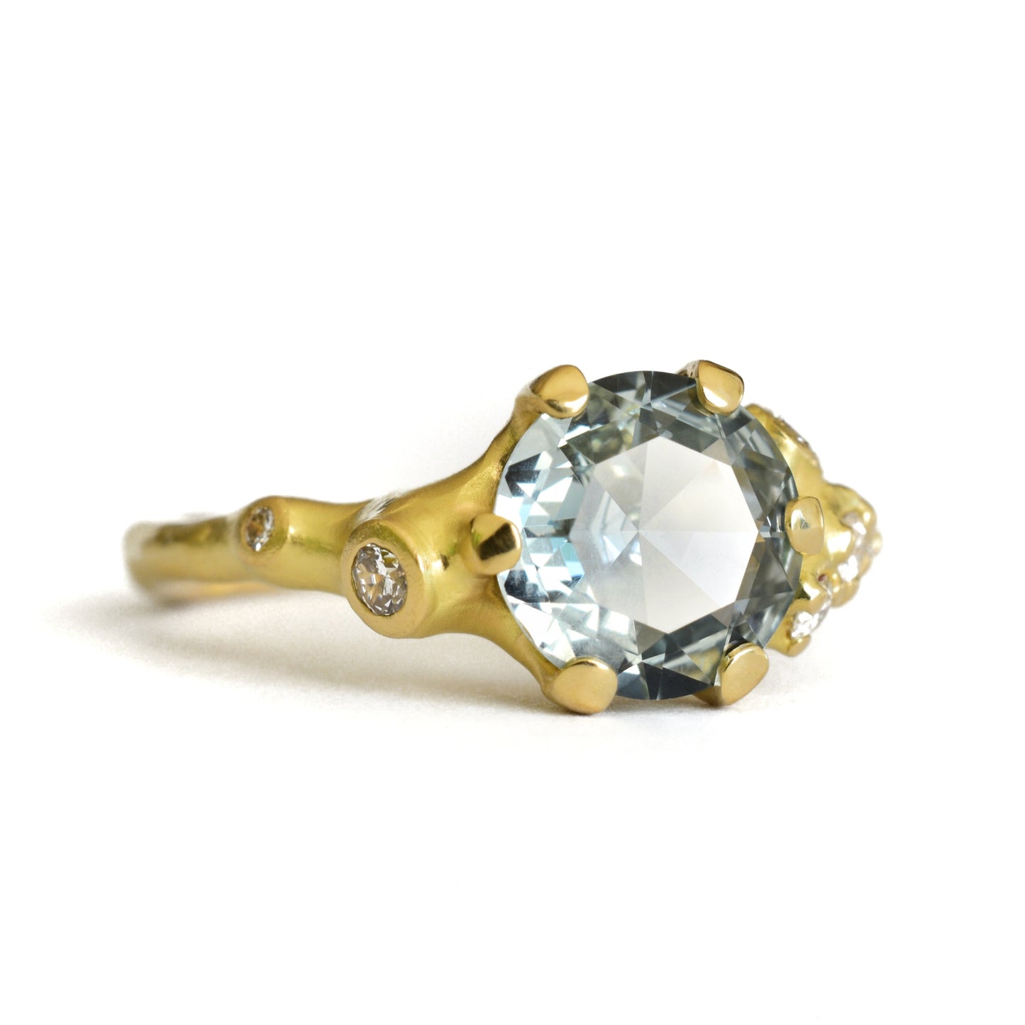Johnny Ninos Gold ring with a large central gemstone on a white background