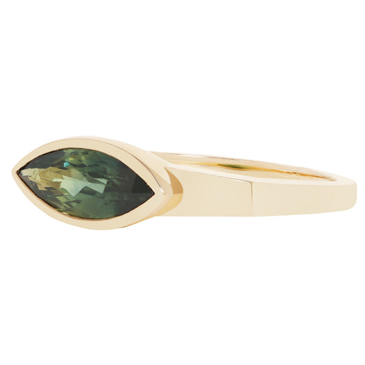 A gold ring featuring a marquise-cut green gemstone in a bezel setting, shown against a plain white background.