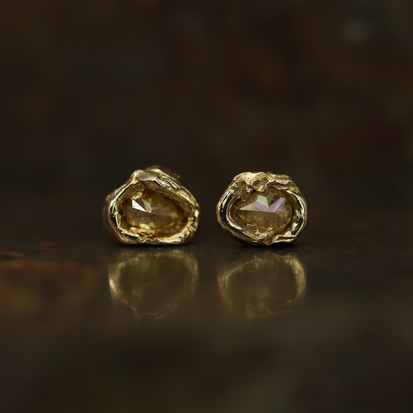 Ellis Mhairi Cameron - Pair of gold earrings with a dark background