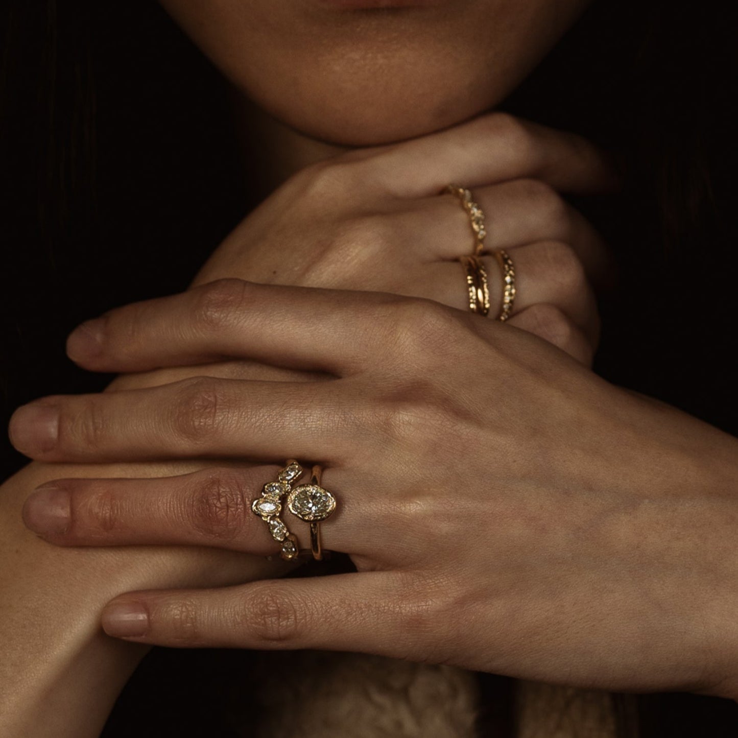 Ellis Mhairi Cameron - Close-up of hands with gold rings on a dark background