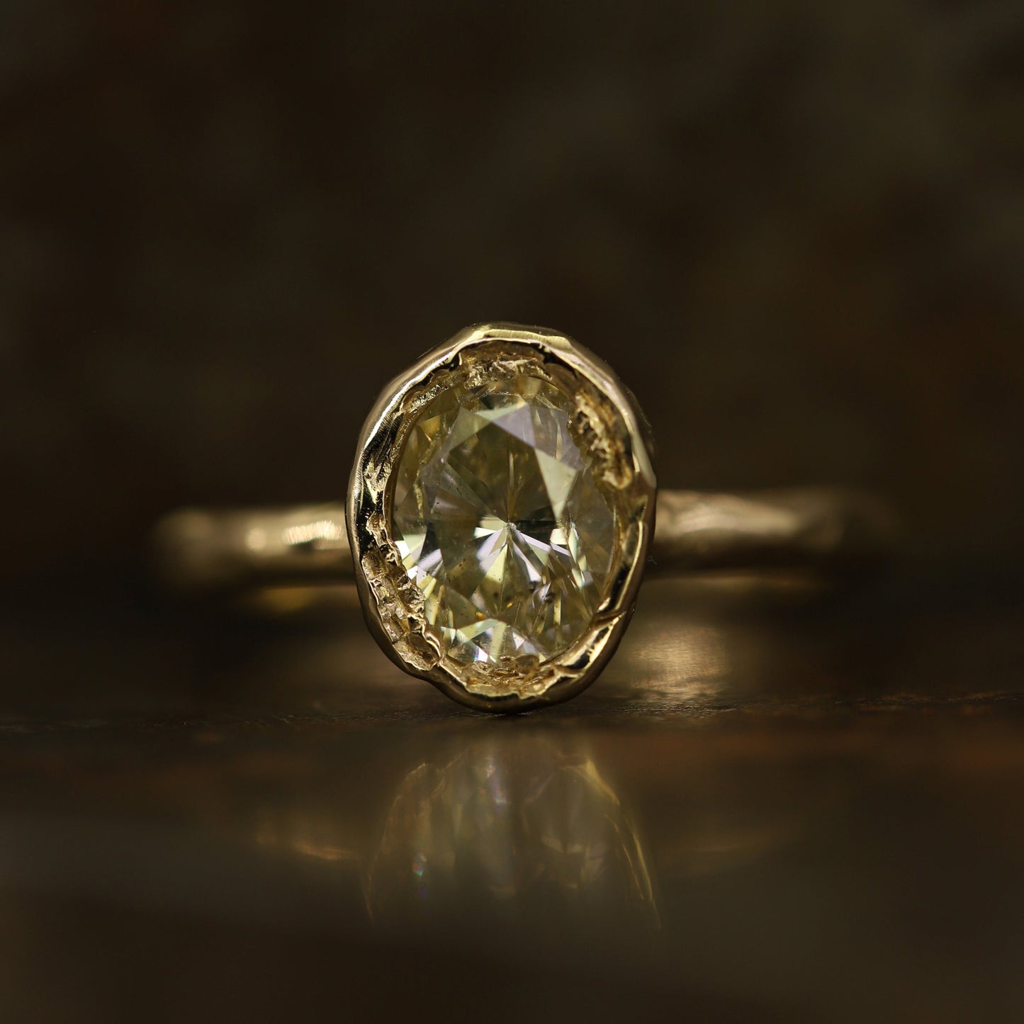 Ellis Mhairi Cameron - Gold ring with a large diamond on a dark background