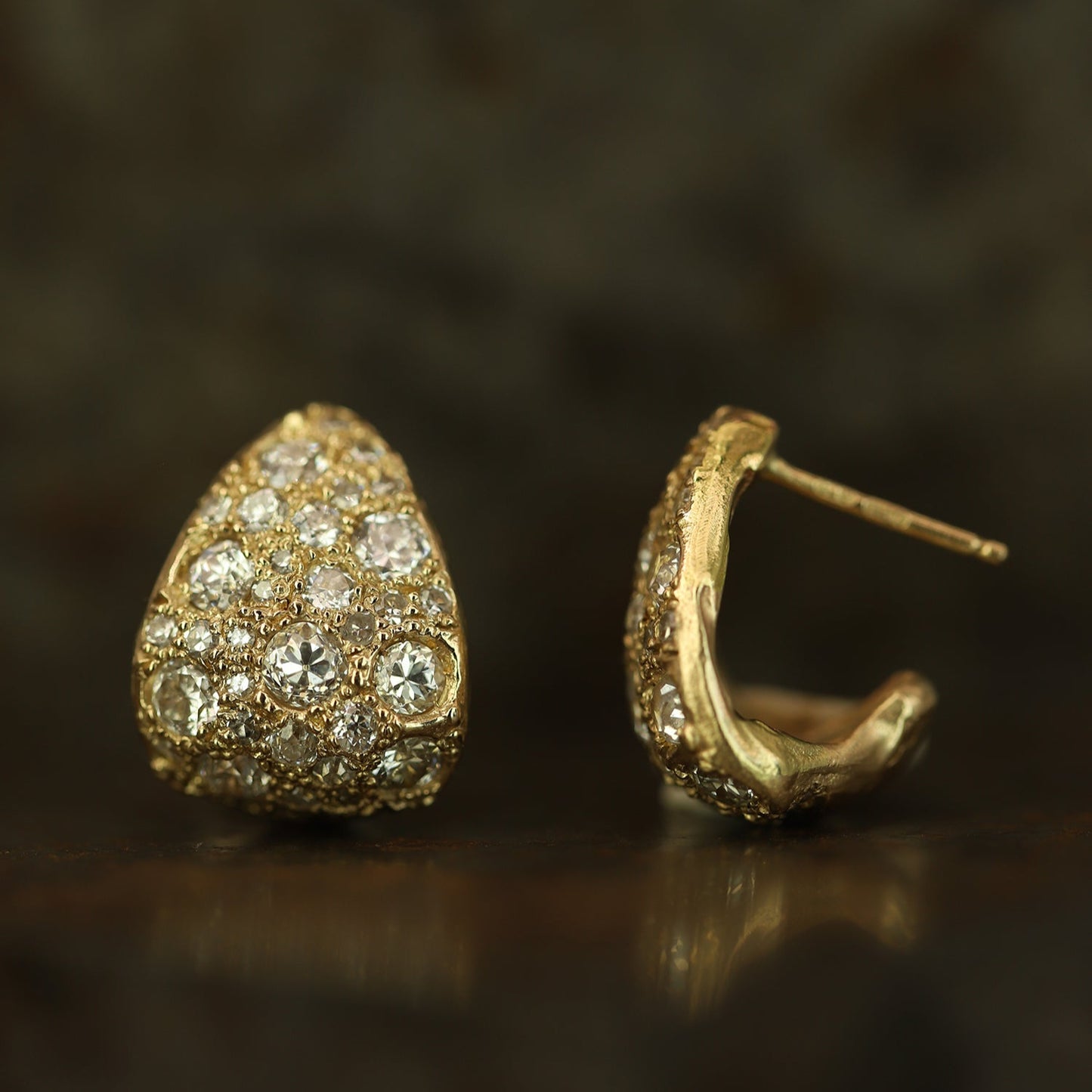 Ellis Mhairi Cameron - Gold earrings with diamond accents on a dark background