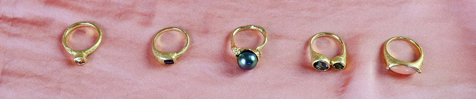five gold rings on pink background