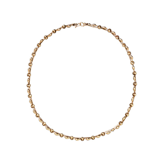 A delicate yellow gold chain necklace with a small clasp, arranged in a circle on a solid white background.