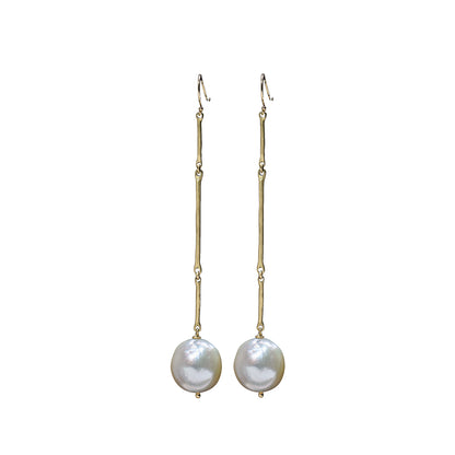 A pair of gold drop earrings with a textured vertical bar, a small bead, and a round white baroque pearl hanging from the end, shown against a plain white background.