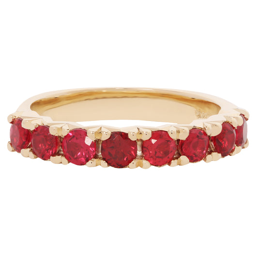 Gold ring with red gemstones on a white background