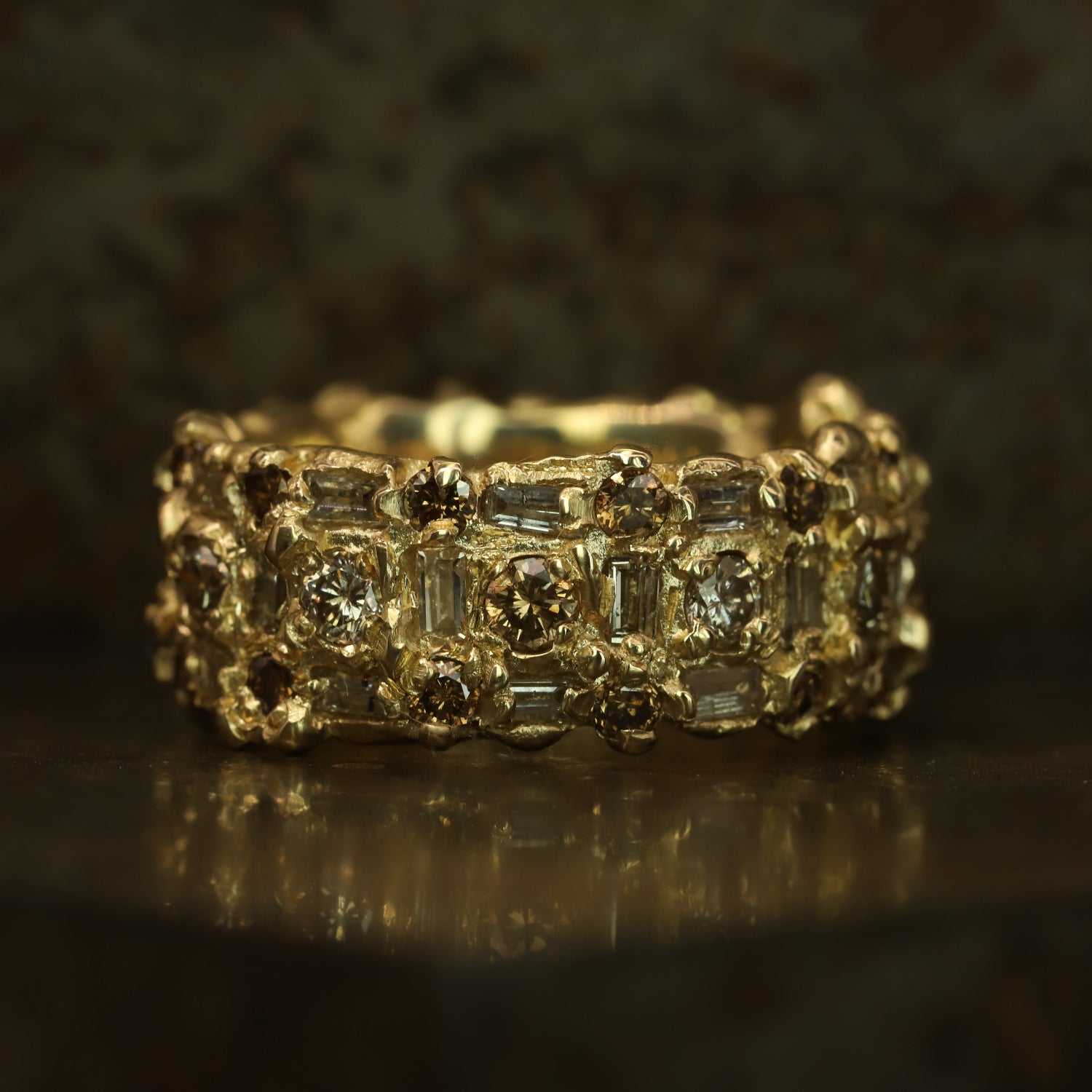 Ellis Mhairi Cameron - Gold ring with diamond accents on a dark background