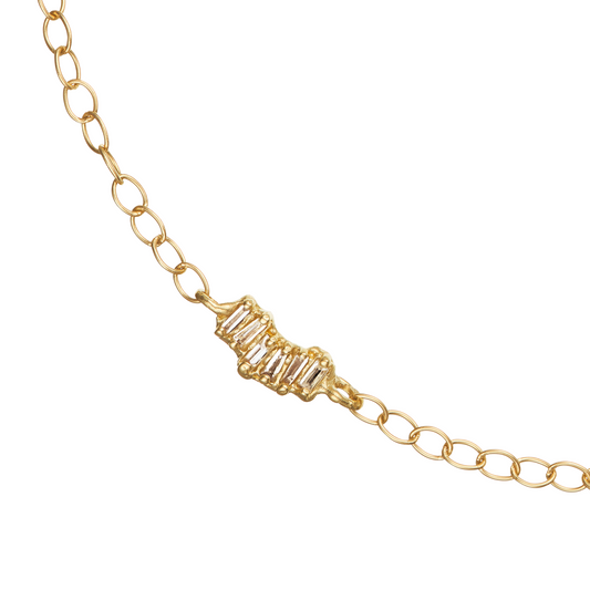 Ellis Mhairi Cameron - Gold bracelet with baguette-cut gemstones on a white background