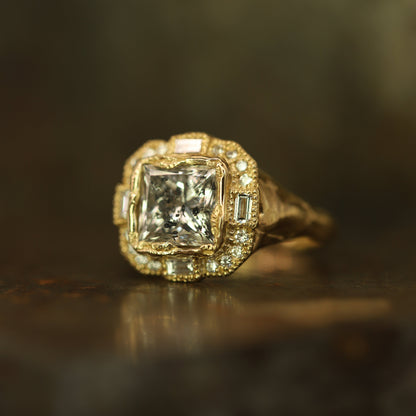 Ellis Mhairi Cameron - Gold ring with a large diamond and smaller diamonds on a dark background