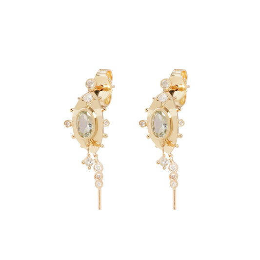 A pair of gold hoop earrings with a central oval green gemstone, surrounded by small clear stones, and featuring dangling chain elements, shown on a plain white background.
