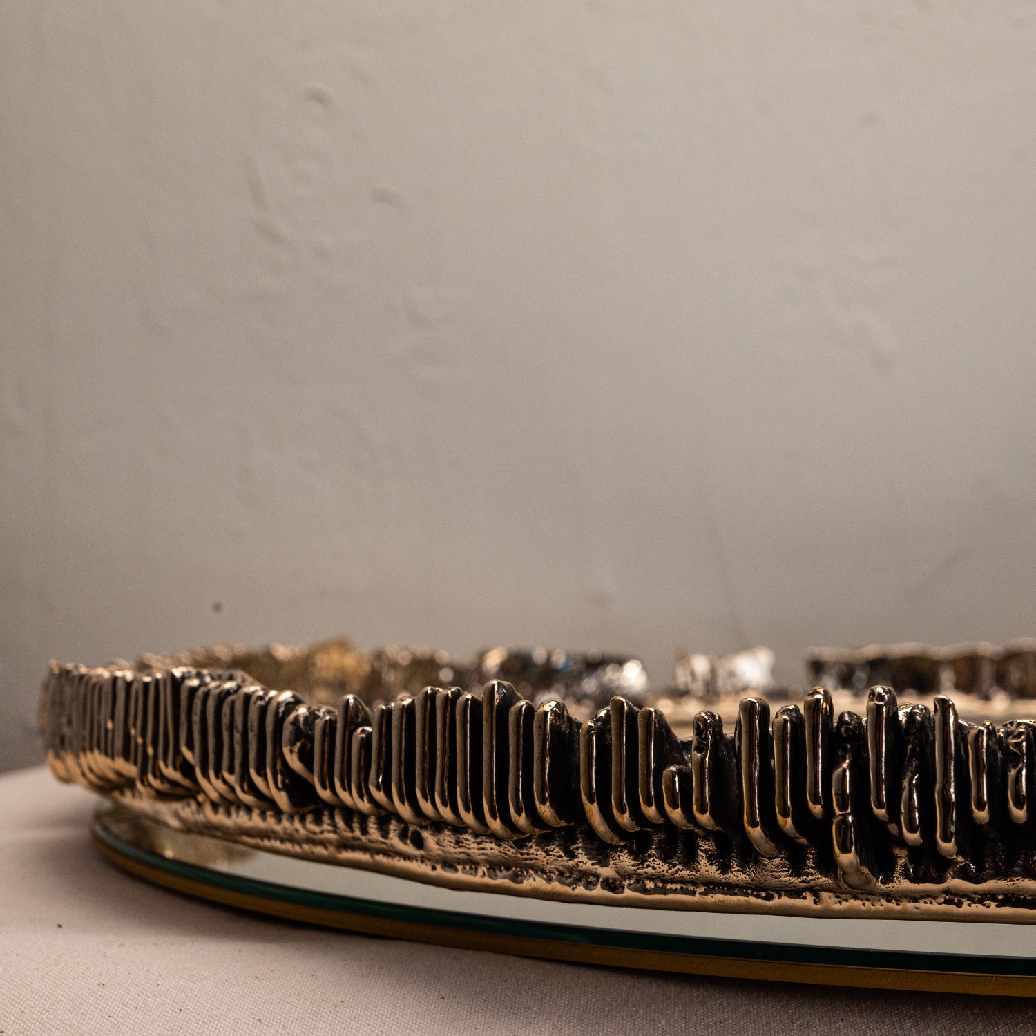 Decorative mirror detailed view of metal textured edge on a neutral background