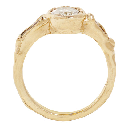 A yellow gold ring featuring a large oval-cut clear center stone and two baguette-cut side stones, shown on a plain white background.