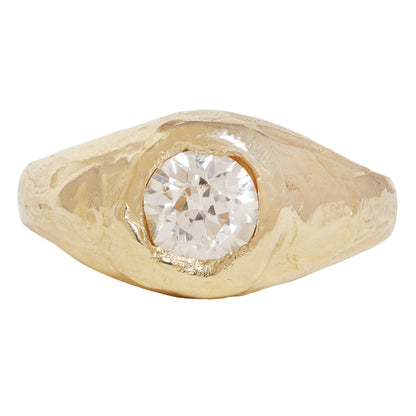 A textured gold signet-style ring featuring a large, round brilliant-cut diamond center stone, shown against a plain white background.