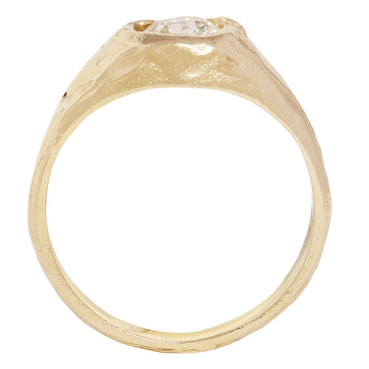 A textured gold signet-style ring featuring a large, round brilliant-cut diamond center stone, shown against a plain white background.