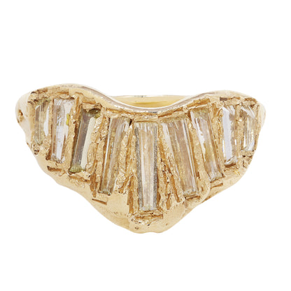A gold ring featuring a wavy, organic shape with multiple baguette-cut clear diamonds set across the top, shown against a plain white background.