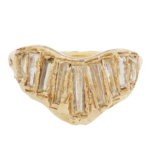 A gold ring featuring a wavy, organic shape with multiple baguette-cut clear diamonds set across the top, shown against a plain white background.