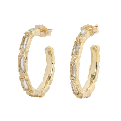Textured gold and diamond hood earring on white background