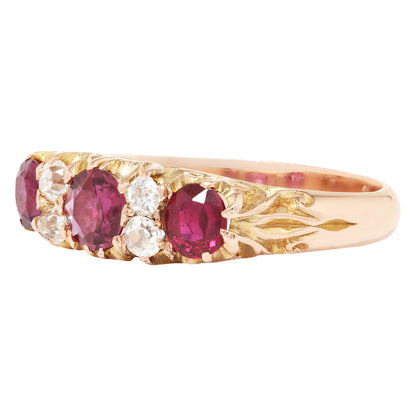 Gold ring with three red gemstones and a clear gemstone on a white background
