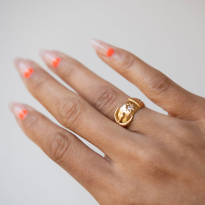 Gold ring on a hand with a neutral background