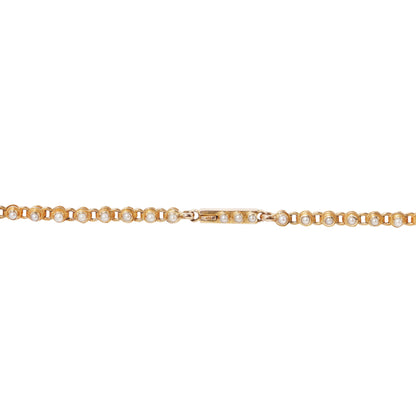 A delicate gold necklace featuring small pearls set in round bezel settings, shown against a plain white background.