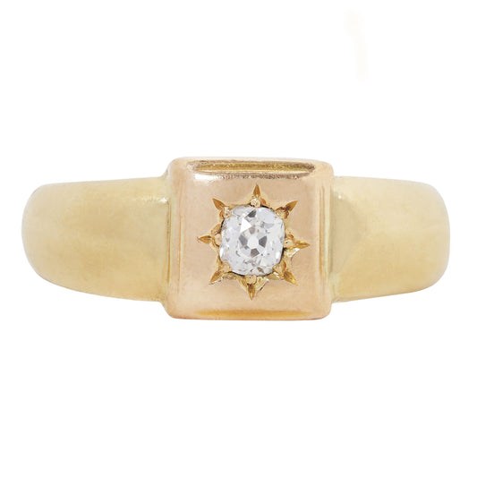 A yellow gold signet-style ring featuring a square bezel-set setting with a central oval clear gemstone surrounded by a starburst-like gold halo, shown on a plain white background.