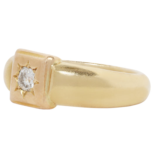 A yellow gold signet-style ring with a square bezel setting and a clear round gemstone, shown on a plain white background.