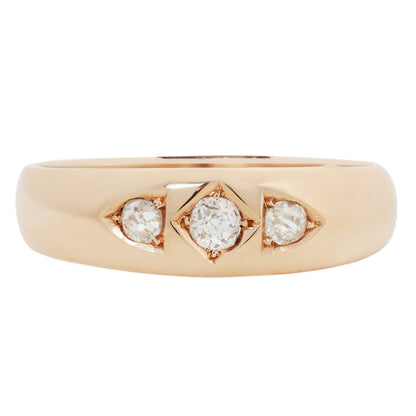 A gold ring with three round-cut diamonds set in a row, photographed on a clean white background.