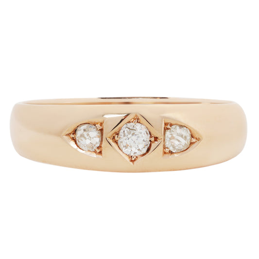 A gold ring with three round-cut diamonds set in a row, photographed on a clean white background.