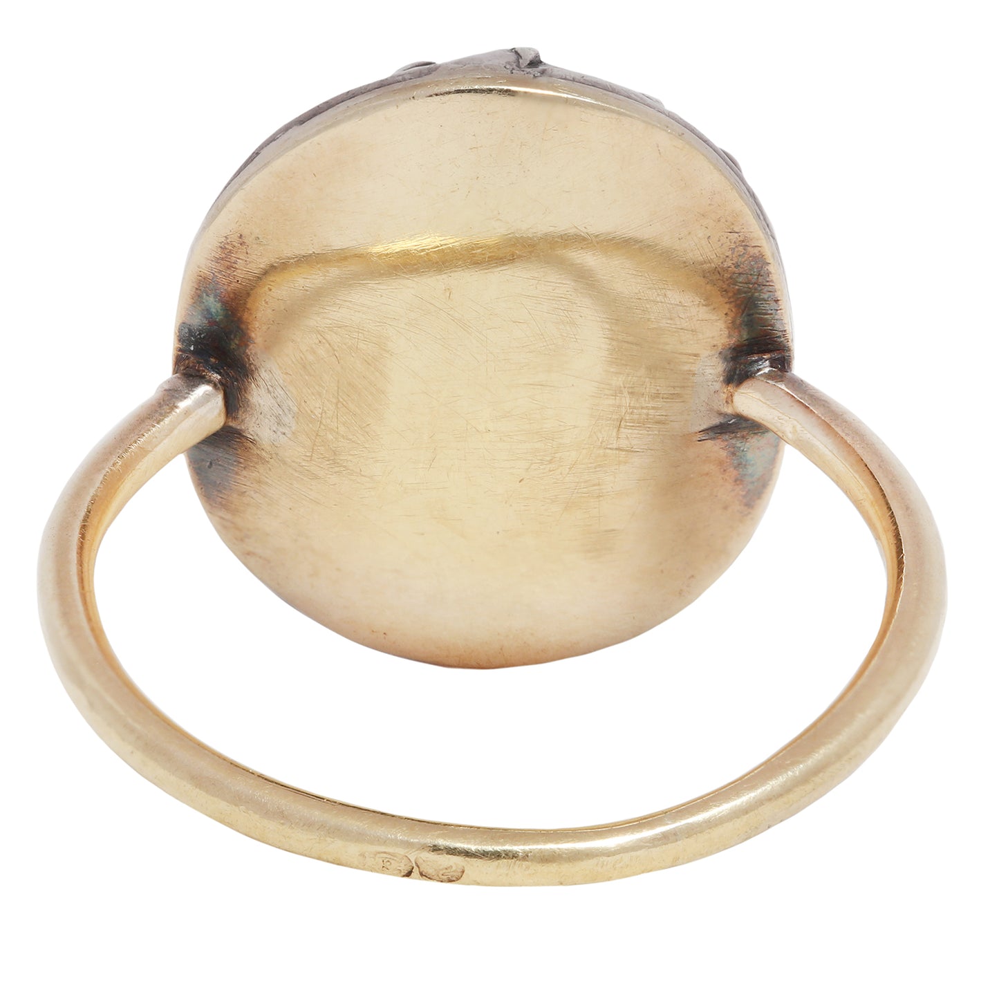 Antique ring with central gemstone and smaller green stones on a white background