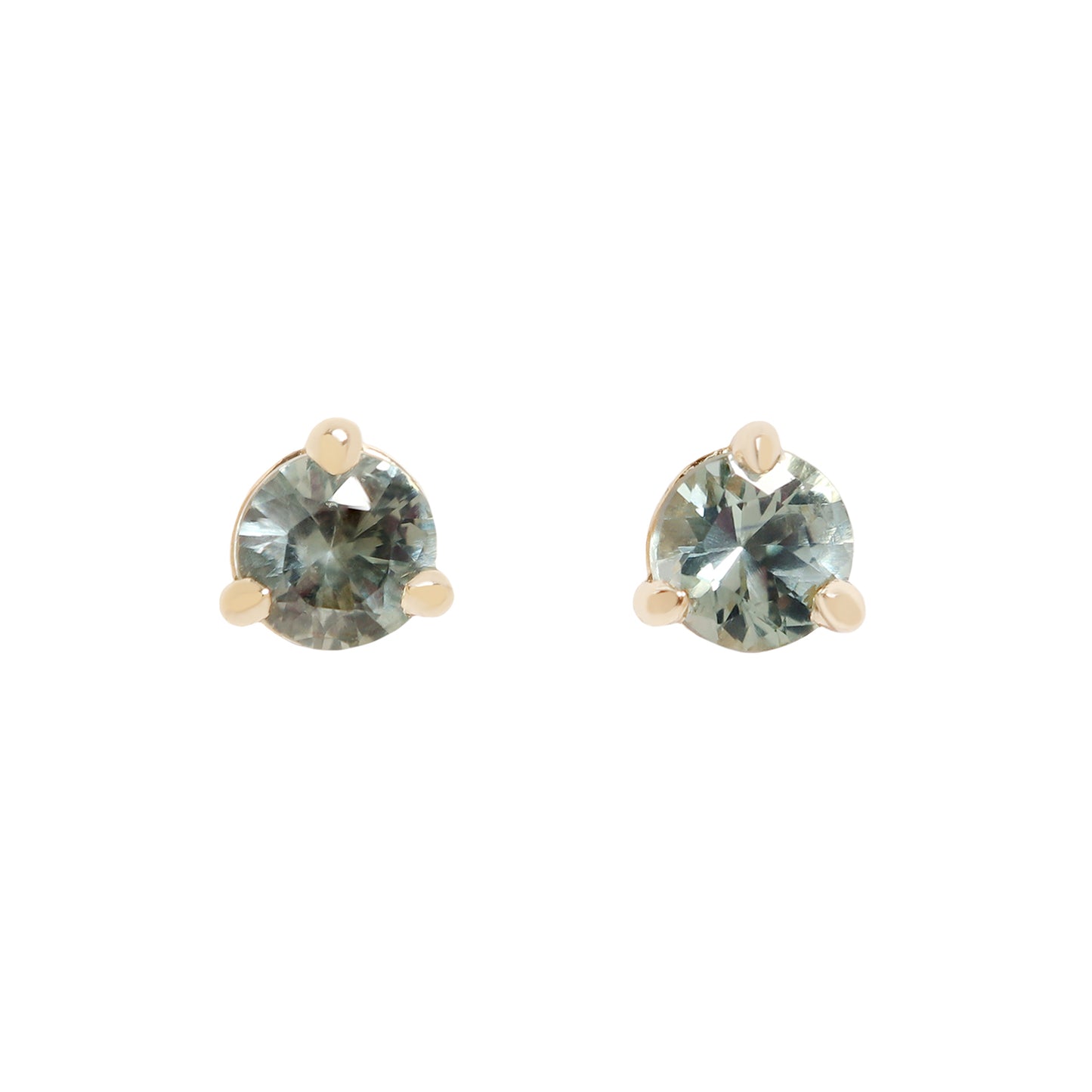 A pair of gold stud earrings with round-cut, faceted gray blue green gemstones, set in a three-prong setting against a plain white background.