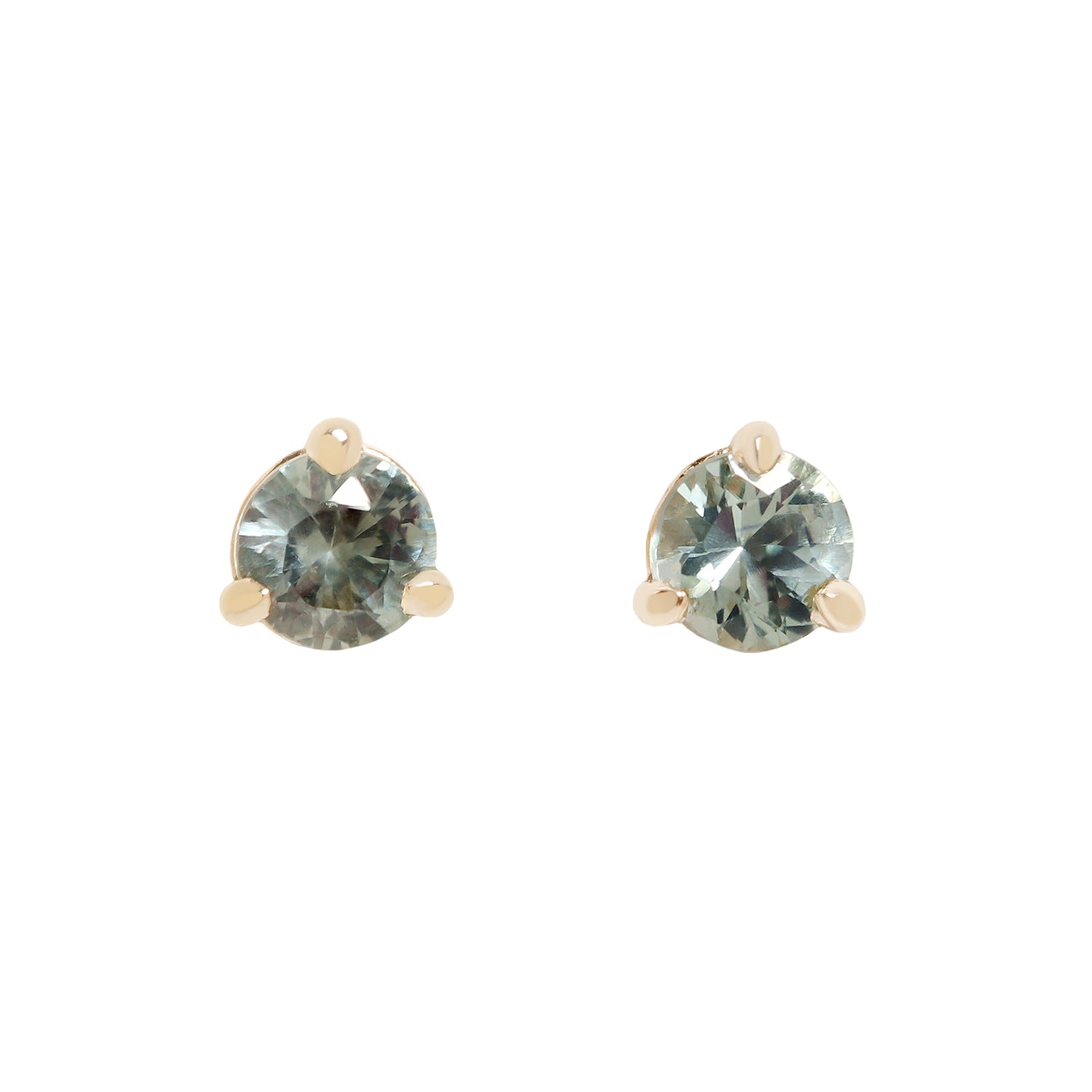 A pair of gold stud earrings with round-cut, faceted gray blue green gemstones, set in a three-prong setting against a plain white background.