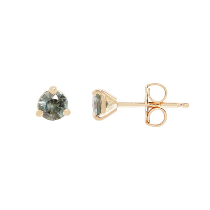 A pair of gold stud earrings with round-cut, faceted gray blue green gemstones, set in a three-prong setting against a plain white background.