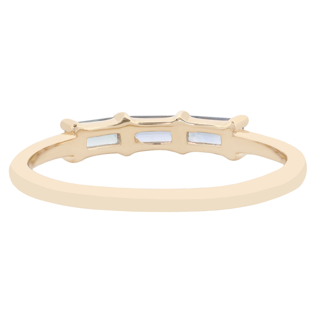A gold band ring featuring three small rectangular blue stones, shown against a plain white background.