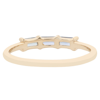 A gold band ring featuring three small rectangular blue stones, shown against a plain white background.
