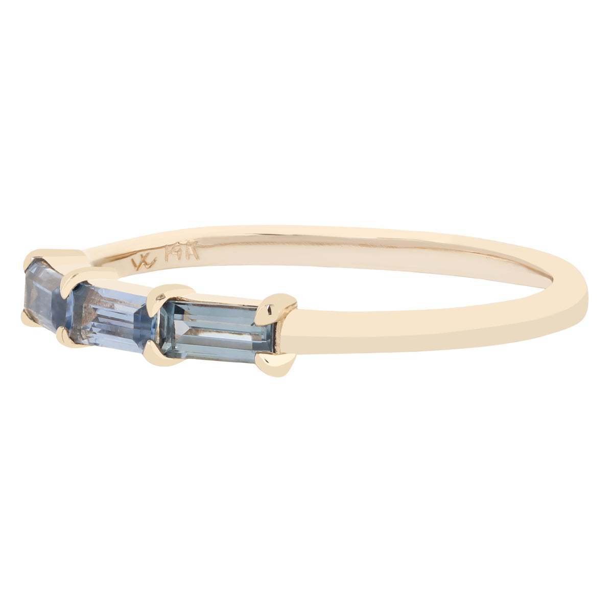 A yellow gold ring featuring three rectangular blue gemstones in a row, set against a plain white background.