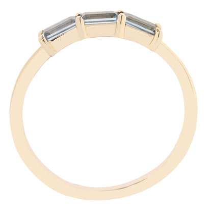 A yellow gold ring with three rectangular baguette-cut clear gemstones in a three-stone setting, shown against a plain white background.