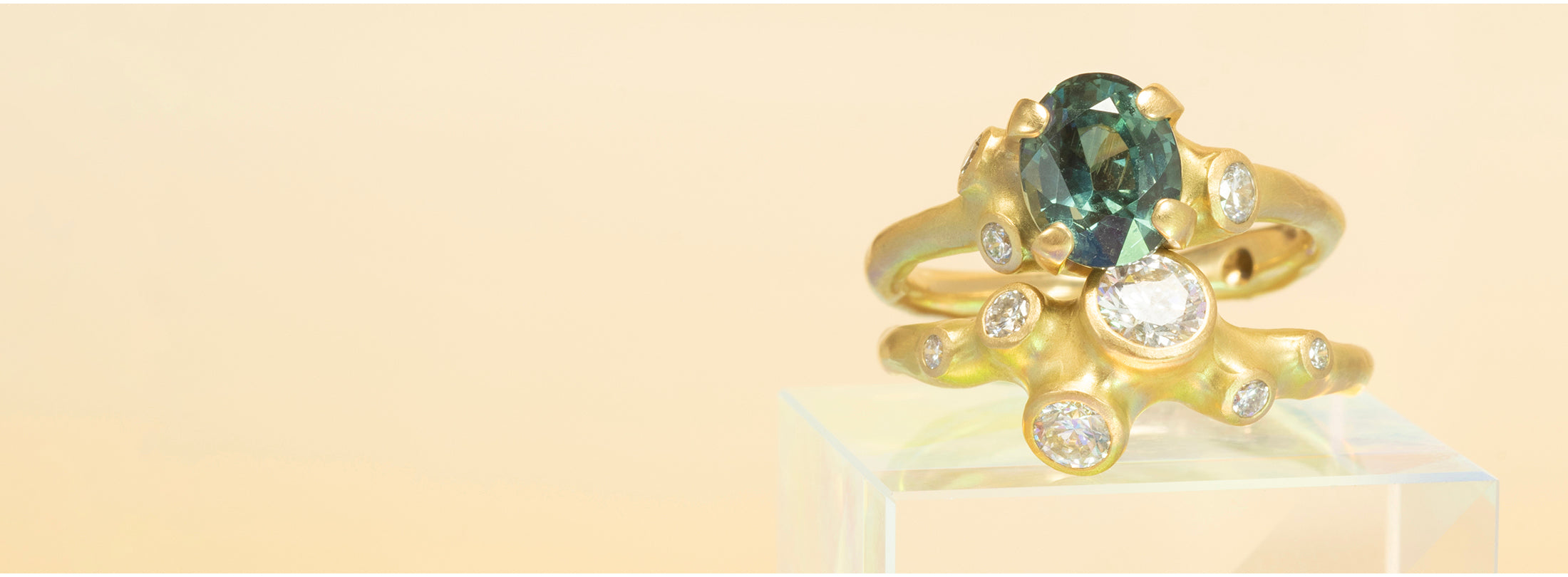 Gold rings with blue sapphire and diamonds on a beige background