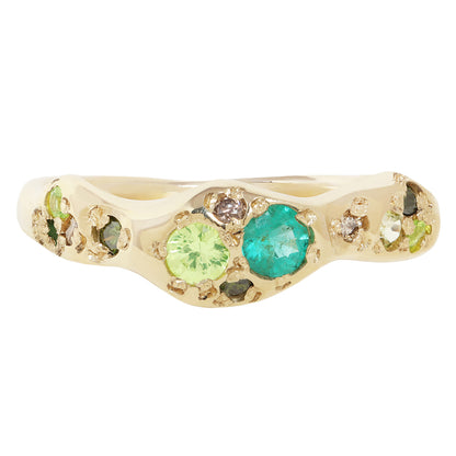 A gold band ring featuring two prominent round gemstones, one light green and one turquoise blue, surrounded by smaller assorted colored stones on a white background.