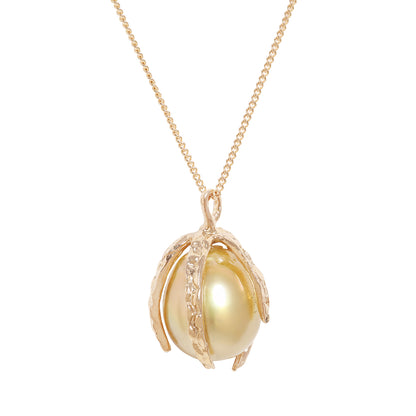 A gold pendant necklace featuring a large, lustrous yellow pearl nestled within a textured gold shell-like setting, suspended from a delicate gold chain against a solid white background.